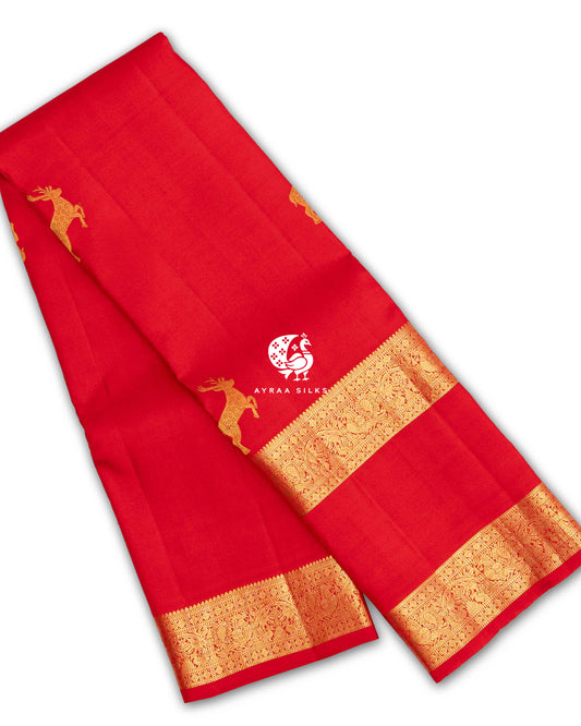 Red pure Kanchipuram silk saree folded, with Maan (deer) zari buttas and a Rettai Pettu (double) gold zari border