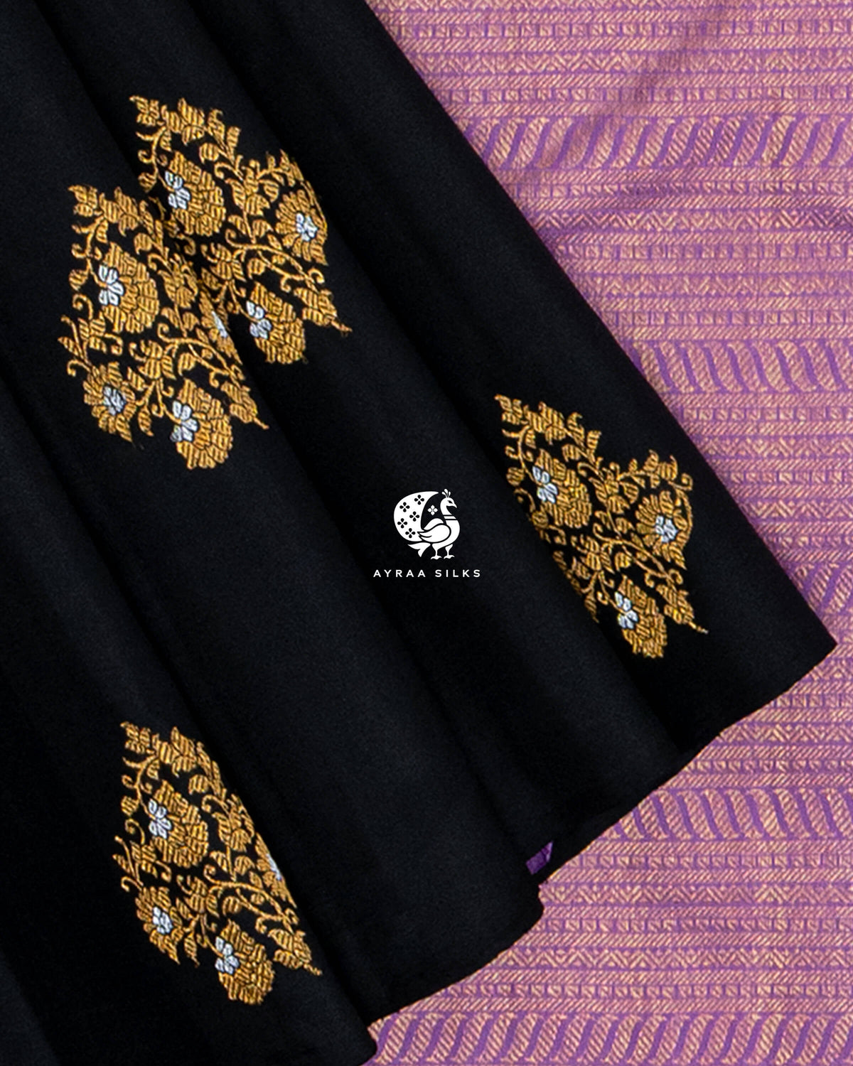 Black pleats with floral zari buttas against the fine zari stripes of the lavender pallu