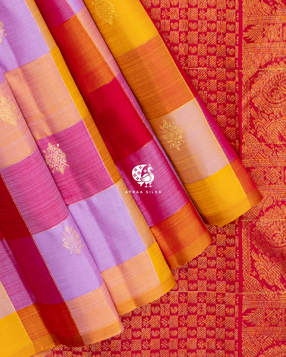 Close view of the borderless edge of the multicolour checked pleats against the red zari pallu in small checks