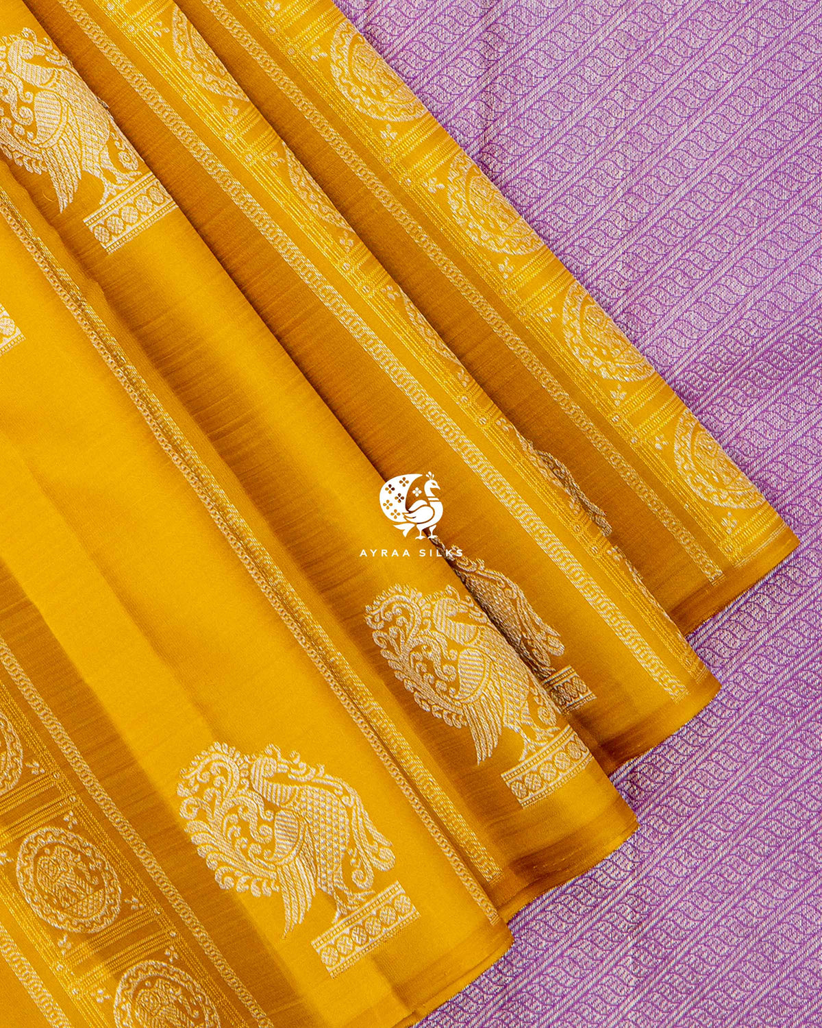 Close view of Annam (swan) zari buttas on mustard pleats against the lavender silver zari pallu