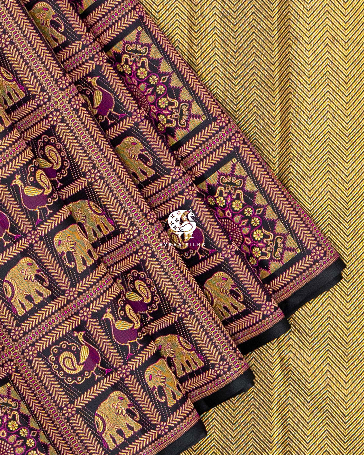 Close view of brocade pleats with Yanai (elephant) and Mayil (peacock) motifs against the gold zari chevron pallu