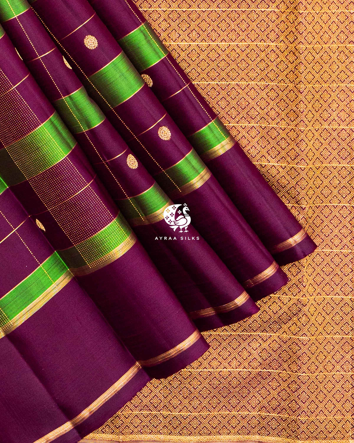 Wine and green Kattam silk in diagonal folds showing round zari buttas and dotted zari lines in pure zari