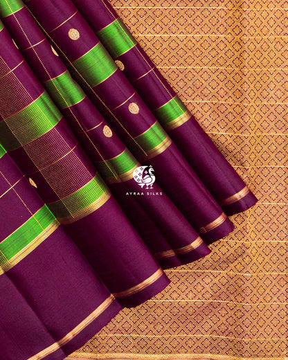 Wine and green Kattam silk in diagonal folds showing round zari buttas and dotted zari lines in pure zari