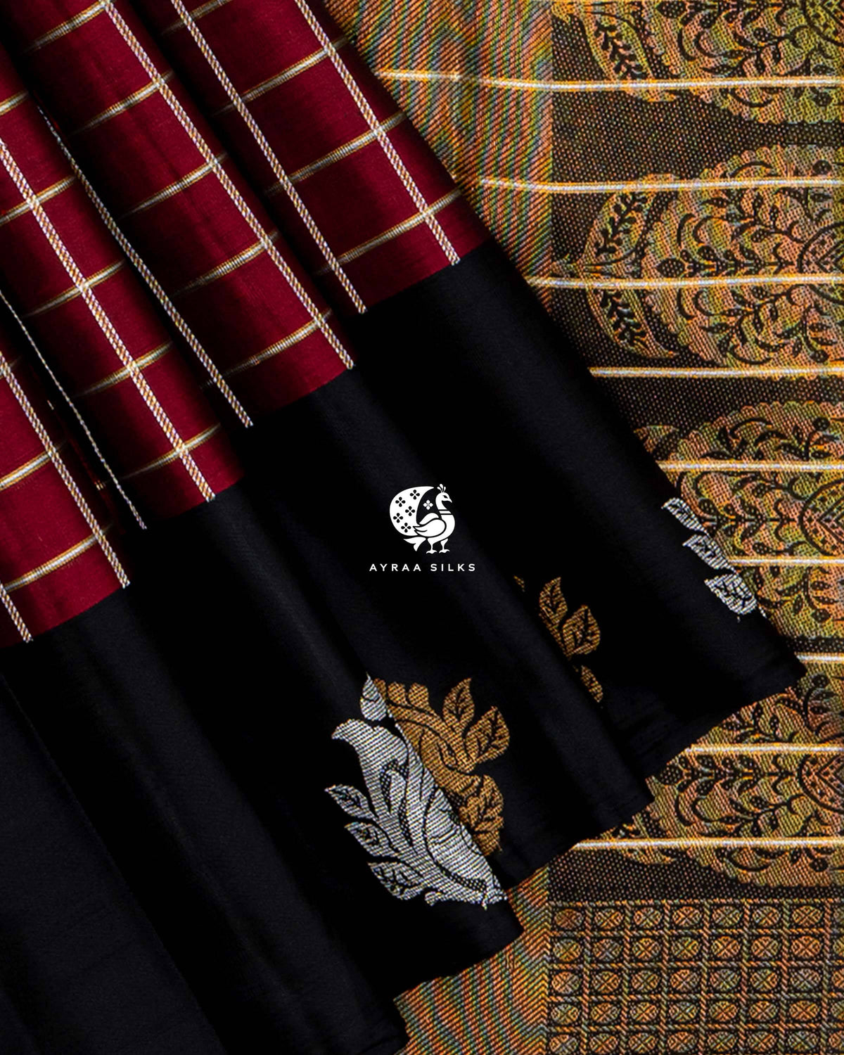 Close view of gold and silver zari Mayil (peacock) motifs on the black border beside the zari medallion pallu
