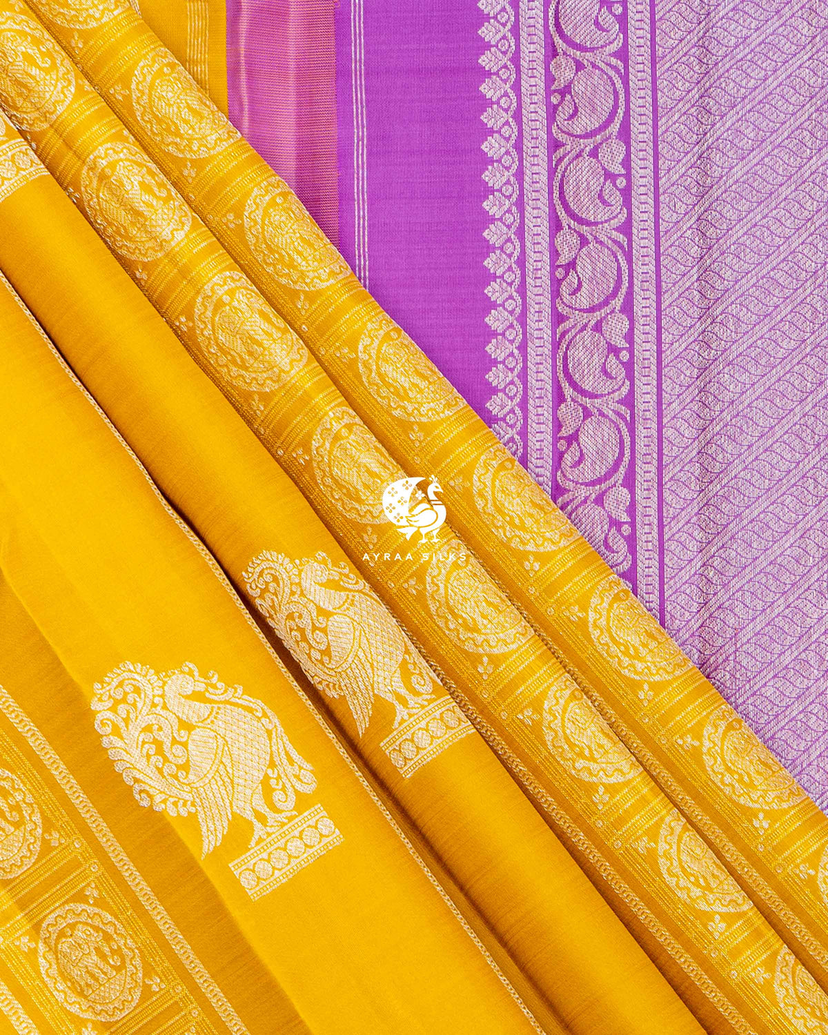 Mustard pleats with Yanai zari medallions beside the purple paisley vine border of the lavender pallu