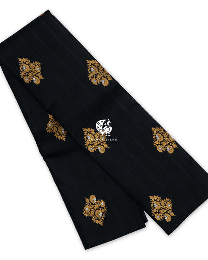 Black pure Kanchipuram silk saree folded, with large floral vine buttas in gold zari and silver zari flowers
