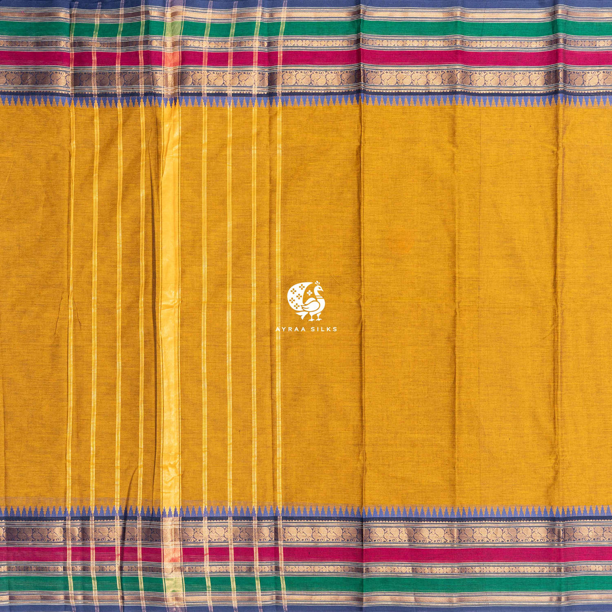 Mustard Kanchi cotton saree laid flat, pallu with zari lines and the triple petta temple border
