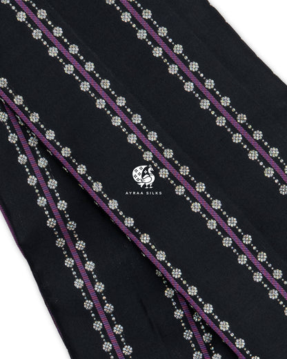 Close view of purple Vari (stripes) flanked by silver-toned floral zari buttas on black pure Kanchipuram silk