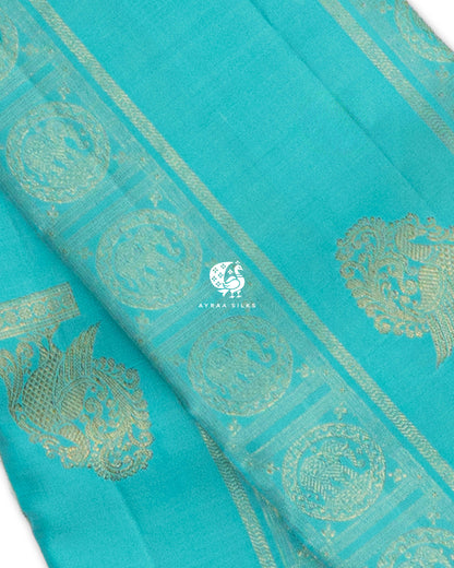 Close view of Mayil (peacock) zari buttas and Chakra medallions on a turquoise blue pure Kanchipuram silk saree
