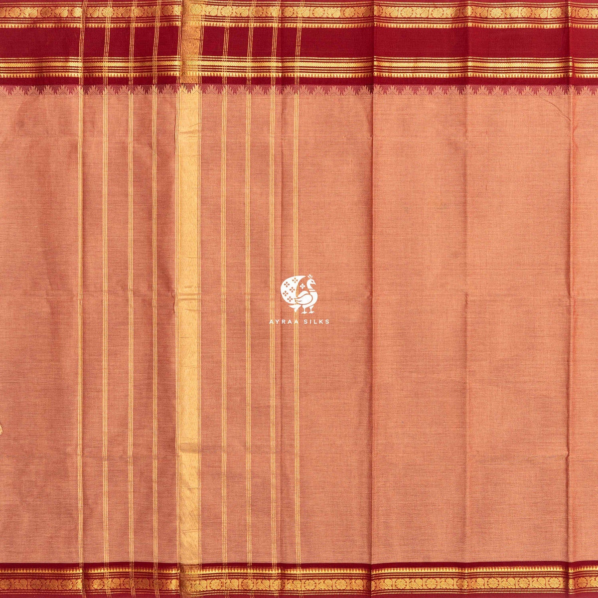 Peach Kanchi cotton saree laid flat, pallu with zari lines and the brick red zari temple border