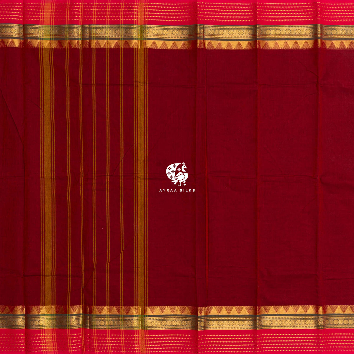 Maroon Kanchi cotton saree laid flat, pallu with stripes and the green and pink zari temple borders