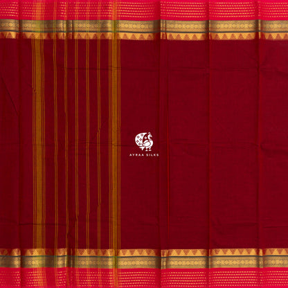 Maroon Kanchi cotton saree laid flat, pallu with stripes and the green and pink zari temple borders