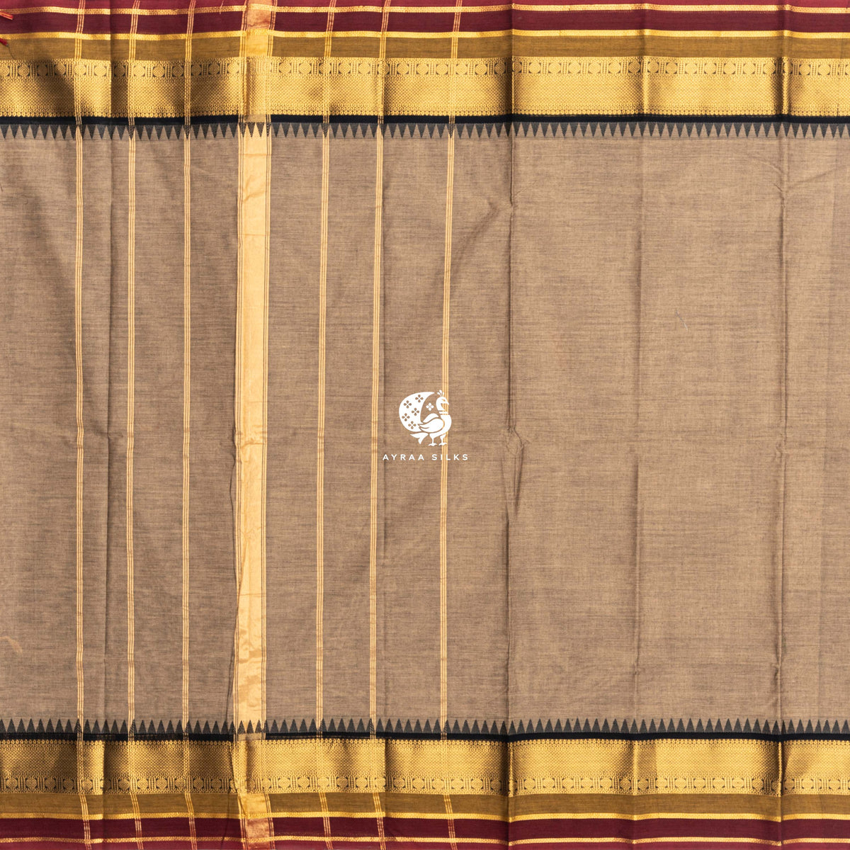 Beige Kanchi cotton saree laid flat, pallu with zari lines, black temple border and maroon edge