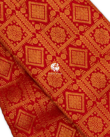Close view of zari brocade on red pure Kanchipuram silk, with floral medallions in square and diamond frames and leaf vines