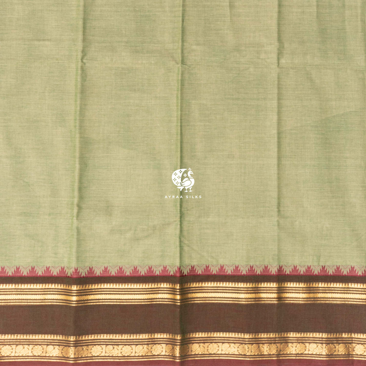 Plain pista green cotton body meeting the brown temple kumbam border in gold zari