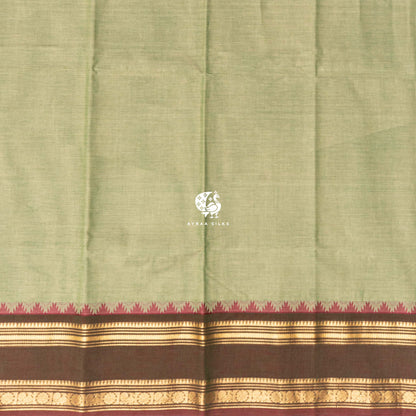 Plain pista green cotton body meeting the brown temple kumbam border in gold zari