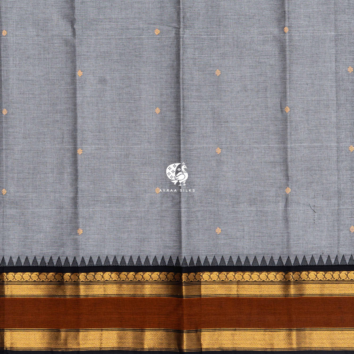 Gold zari buttas across the grey Kanchi cotton body, meeting the black temple kumbam border