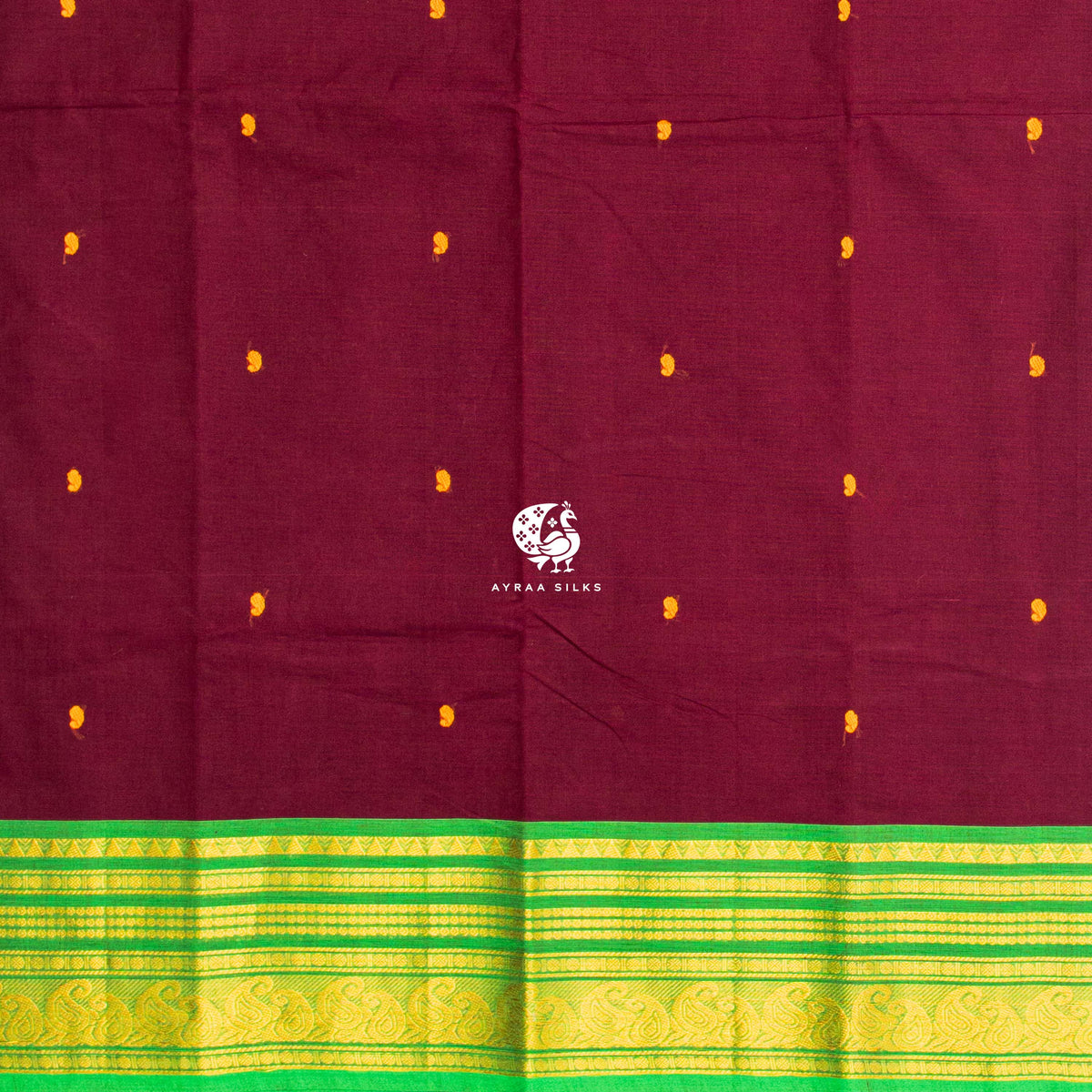 Mustard thread buttas across the maroon body, meeting the green zari border