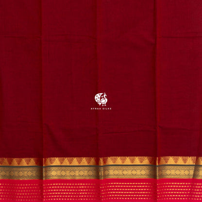 Plain maroon body of the handwoven cotton saree meeting the gold zari temple kumbam border