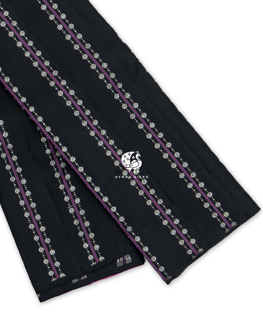 Black Kanchipuram pattu saree with purple stripes and floral zari buttas, showing the borderless edge