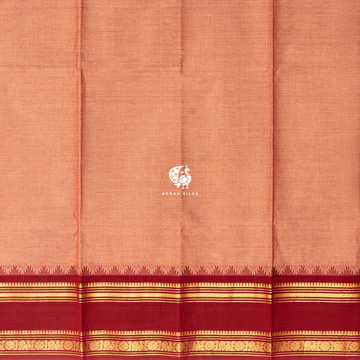 Plain peach cotton body meeting the brick red temple kumbam border in gold zari