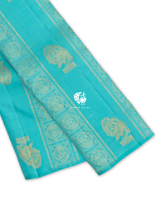 Turquoise blue Kanchipuram pattu saree showing peacock zari buttas between zari bands of elephant Chakra medallions