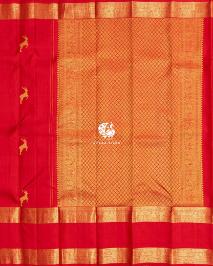 Red zari pallu in diamond weave with Mayil (peacock) side borders beside the red body with deer zari buttas