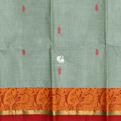 Close view of the red buttas woven into the sage green cotton
