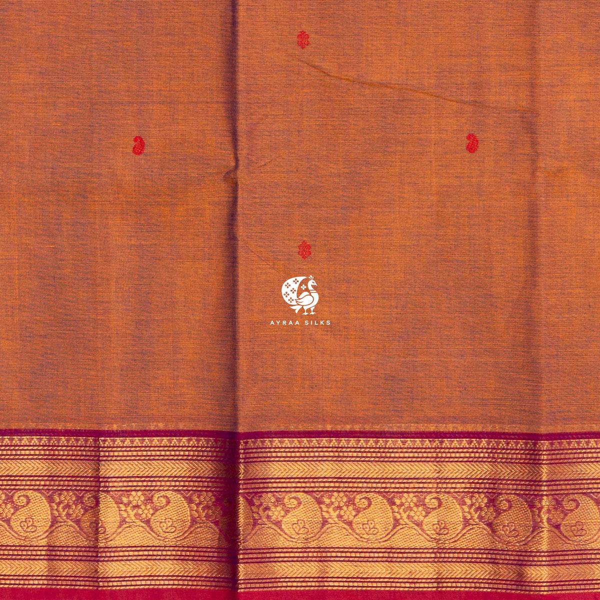 Close view of the red buttas woven into the shot rust cotton