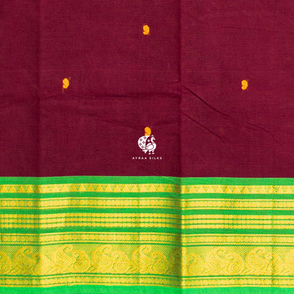 Close view of the mustard buttas woven into the maroon cotton