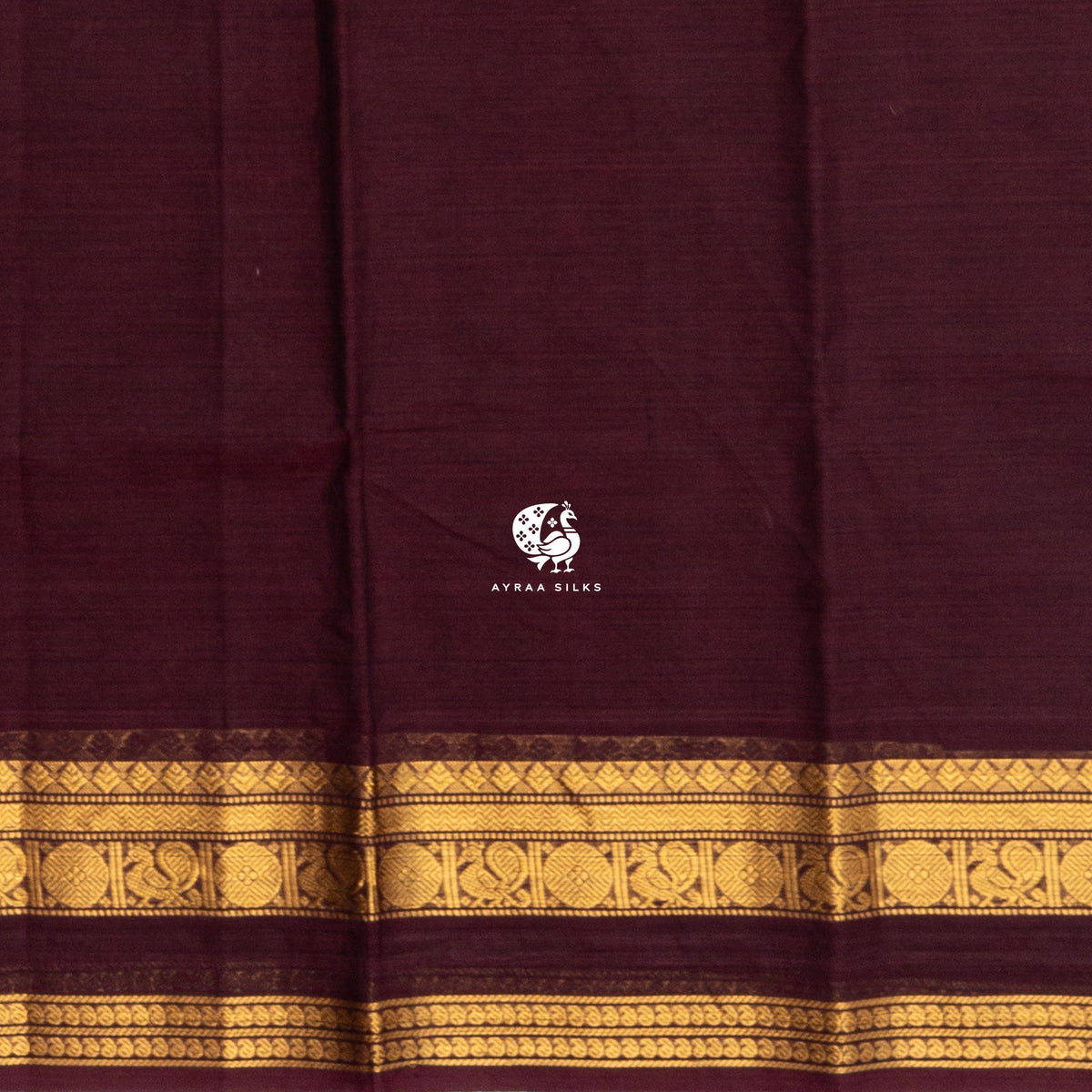 Close view of the running blouse and gold zari border with paisley and geometric roundels on maroon