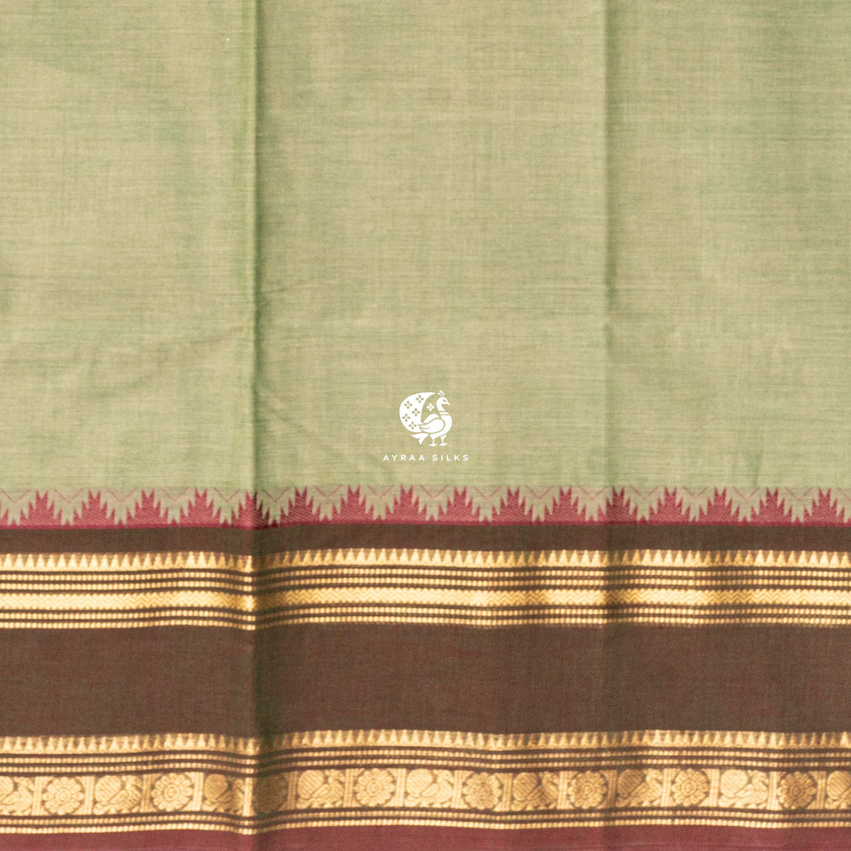 Close view of the running blouse and brown and gold zari border with floral roundels and maroon temple points