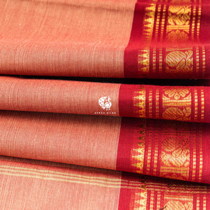Folded stack showing the temple points where the brick red zari border meets the peach body