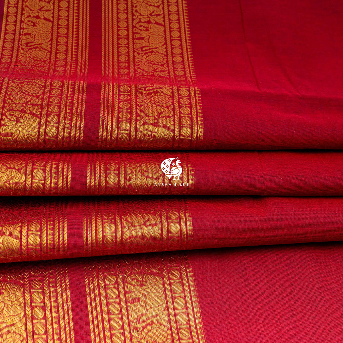 Folded stack showing the depth of the elephant zari border against the red body