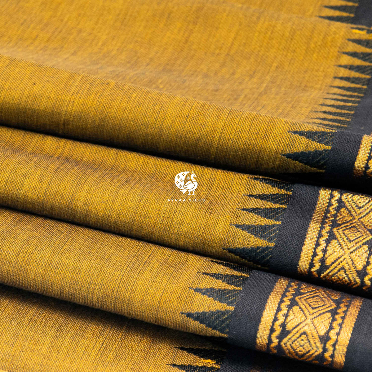 Close view of the running blouse and black zari border with geometric diamonds on mustard