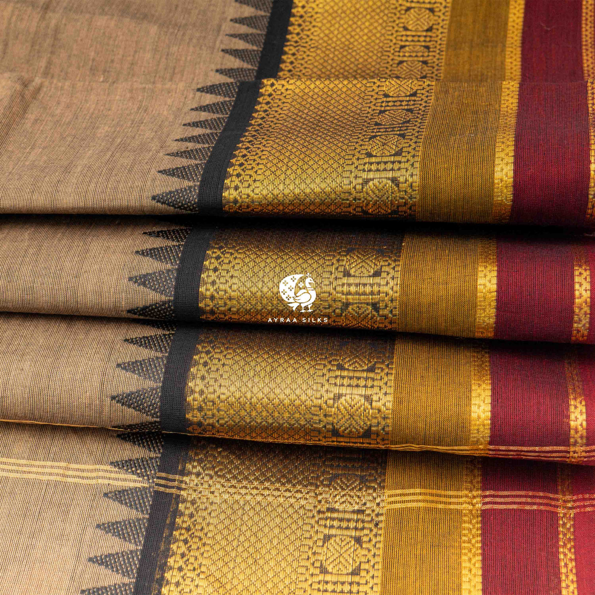Folded stack showing the temple points where the black zari border meets the beige body