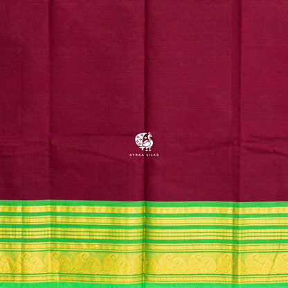 Running blouse in the same maroon as the body, with the same green and gold zari border