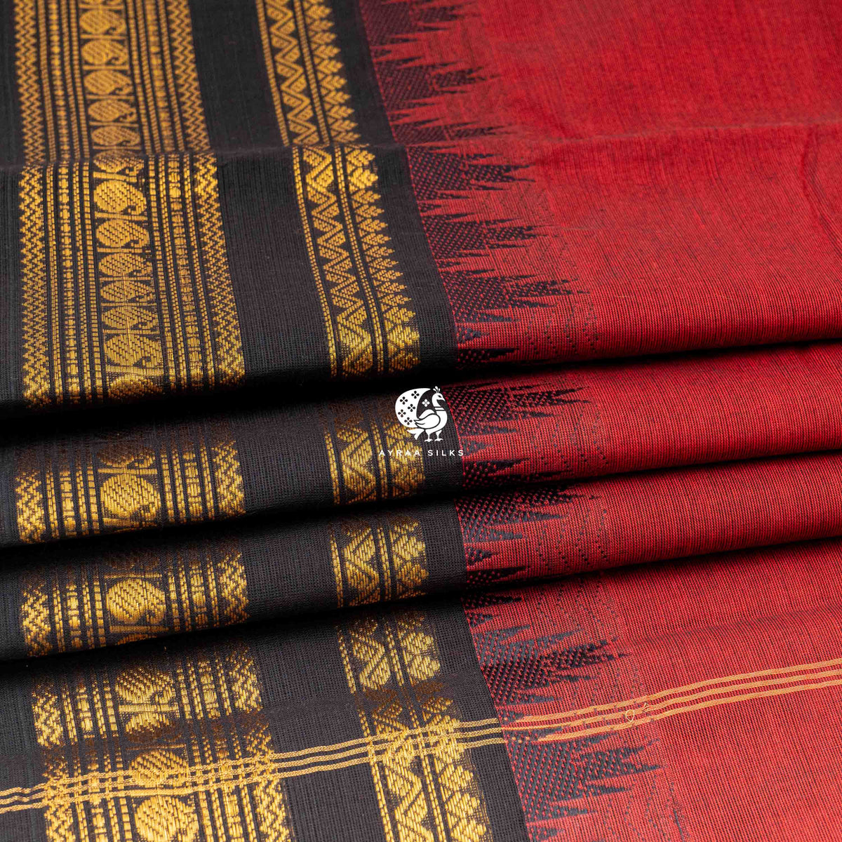Folded stack showing the temple points where the black zari border meets the red body
