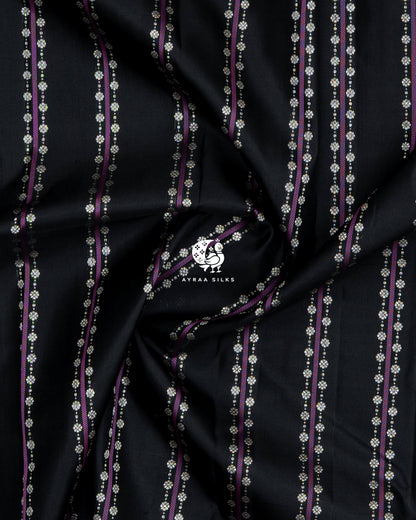 Close-up of the saree body, black silk gathered in soft folds with purple stripes and floral zari buttas