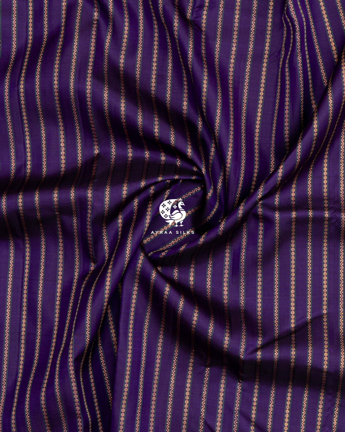 Close-up of the saree body, purple silk gathered in soft folds with floral and wave zari stripes
