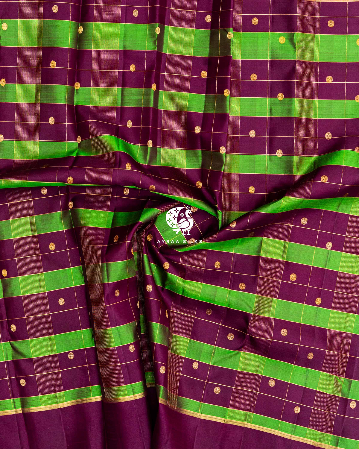 Close-up of the saree body, wine and green checked silk gathered in soft folds with round zari buttas