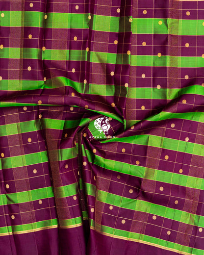 Close-up of the saree body, wine and green checked silk gathered in soft folds with round zari buttas