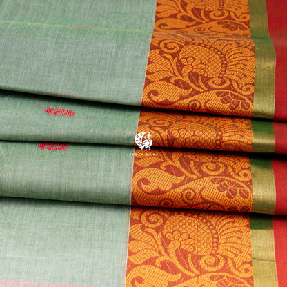 Folded sage green cotton saree showing the orange border with mankolam paisley