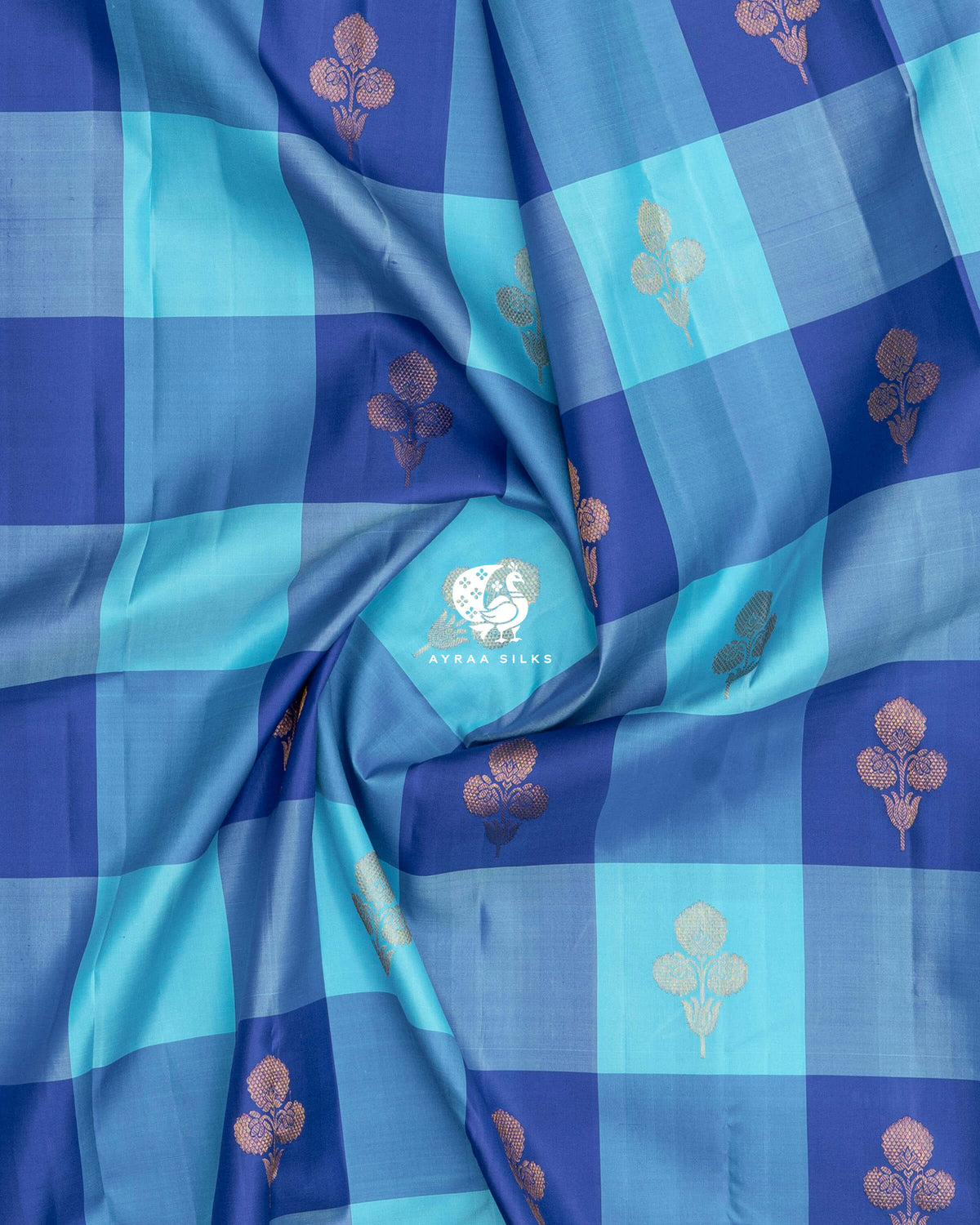 Close-up of the saree body, blue Kattam (checks) with floral zari buttas gathered in soft folds of pure Kanchipuram silk