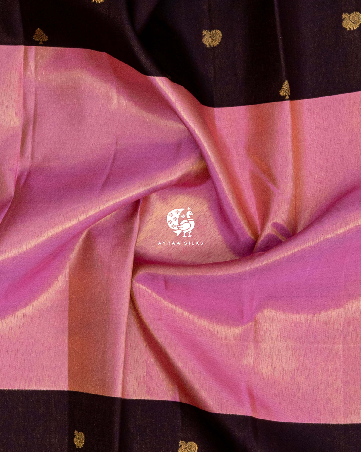 Close-up of the saree body, rose pink zari silk falling in soft folds against coffee brown with Mayil (peacock) zari buttas