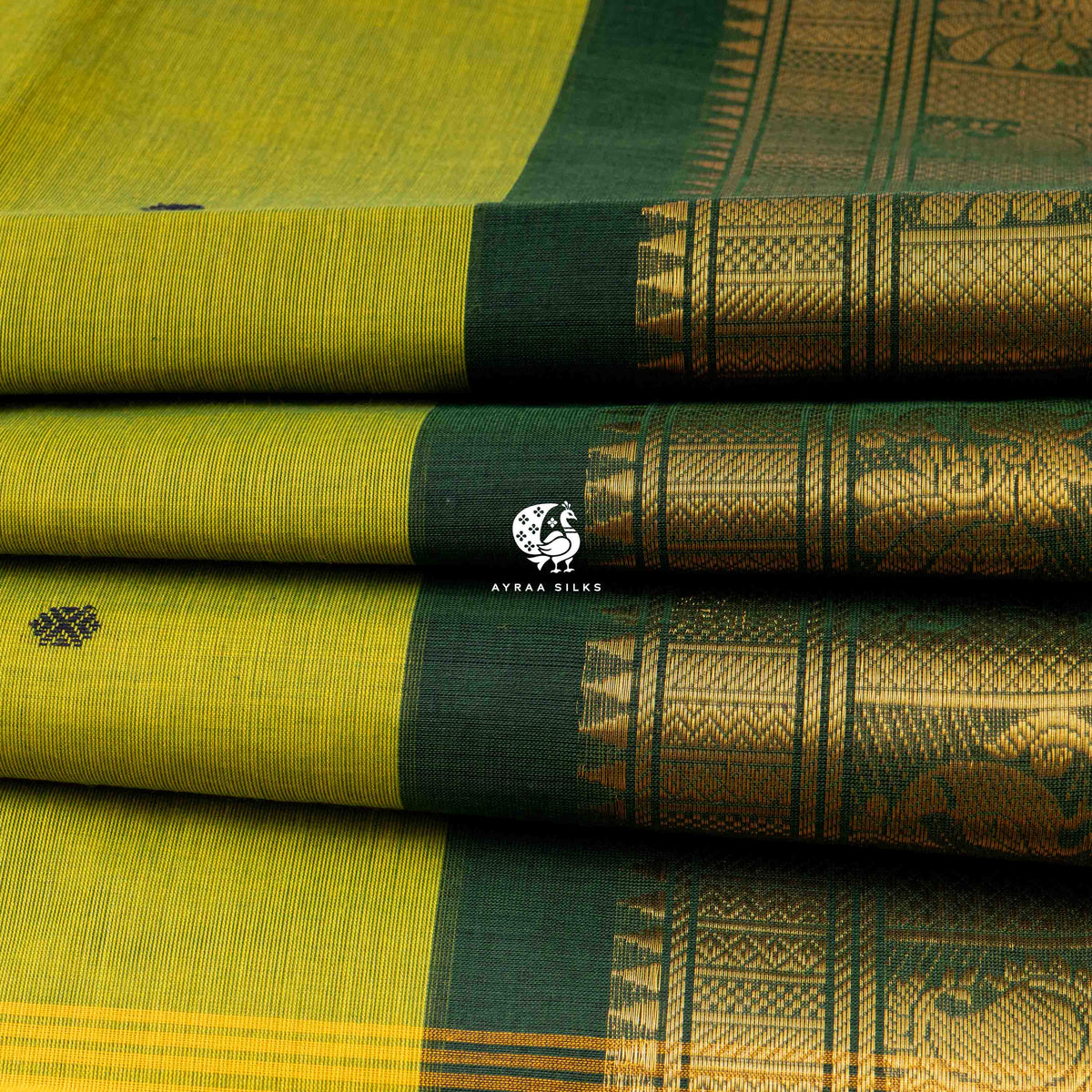 Folded stack showing the depth of the peacock zari border against the mehendi green body