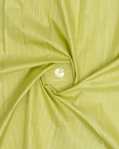 Close-up of the saree body, pista green silk with silver zari lines gathered in soft folds