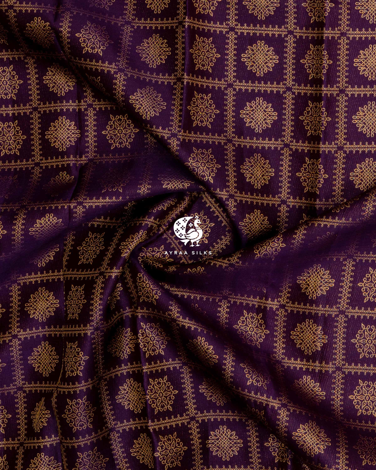 Close-up of the saree body, jamun purple silk gathered in soft folds with zari kolam motifs
