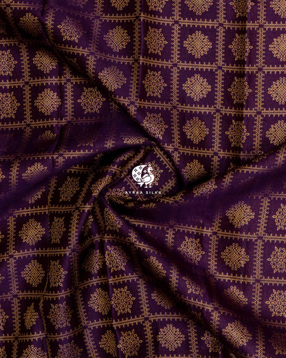 Close-up of the saree body, jamun purple silk gathered in soft folds with zari kolam motifs