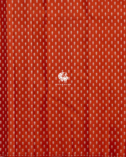 Close view of the running blouse in rust orange pure Kanchipuram silk with rows of floral zari buttas
